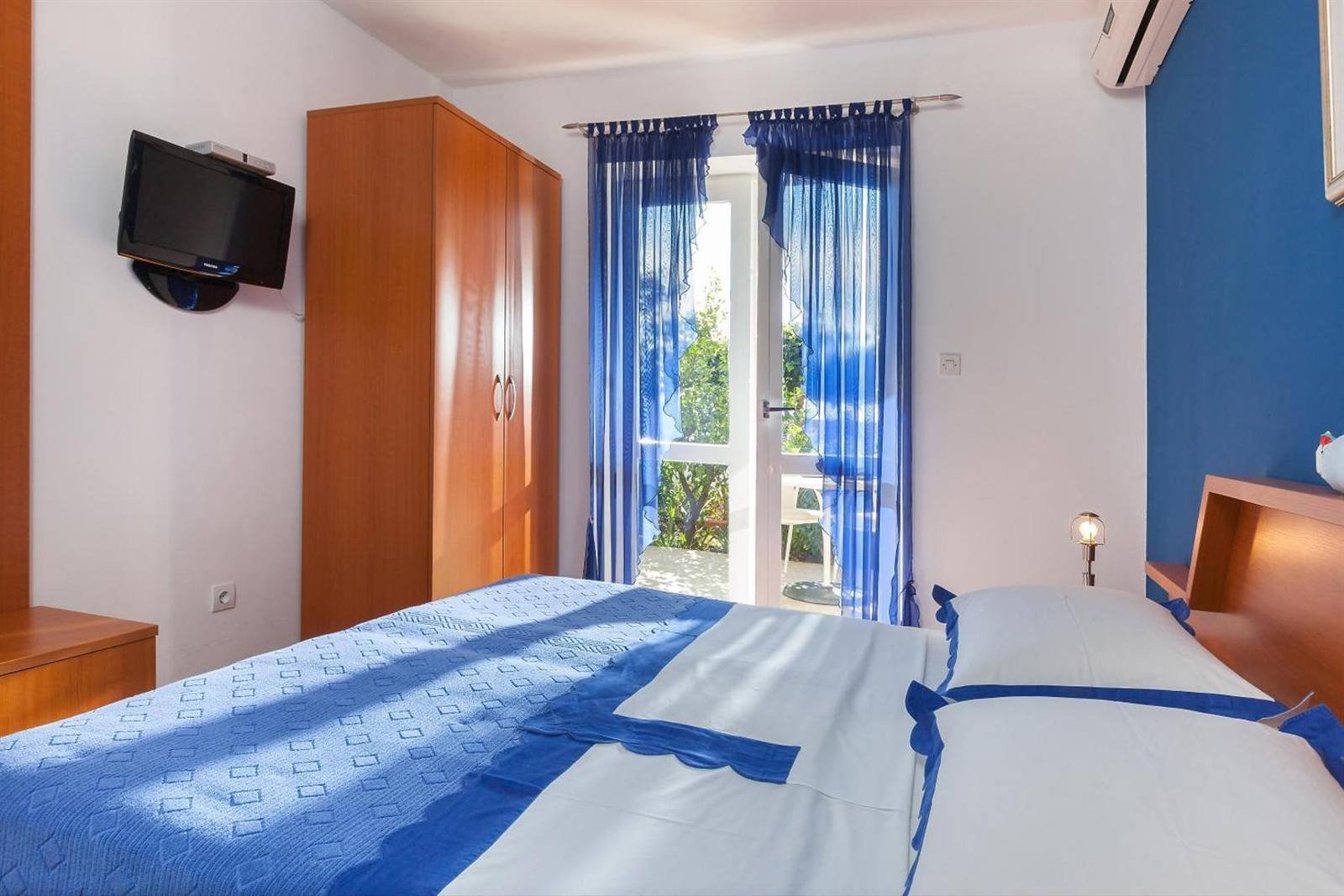 Villa Rosa: bedroom with a blue wall, wardrobe and TV